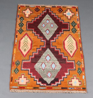 An orange, brown and blue Belouche rug with 2 stylised medallions to the centre 133cm x 86cm 