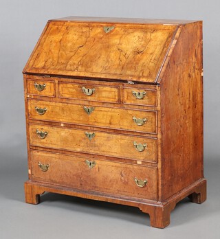 A Queen Anne walnut and crossbanded bureau, the fall front revealing a well fitted stepped interior  with cupboard, pigeon holes, secret drawer and drawers above 3 short and 3 long drawers, raised on bracket feet 104cm h x 88cm w x 50cm d 