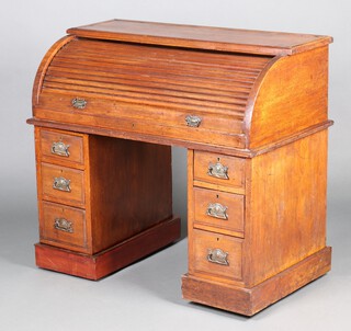 A Victorian walnut cylinder bureau, the interior fitted pigeon holes and 4 short drawers, the base fitted 6 short drawers with embossed metal drop handles 97cm h x 106cm w x 59cm d 