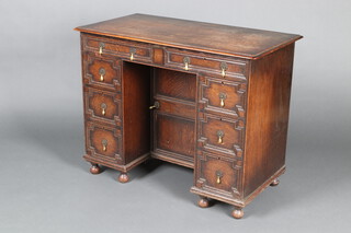 A Victorian Jacobean revival kneehole dressing table/desk with geometric mouldings, fitted 2 long and 6 short drawers, the pedestal fitted a cupboard, raised on bun feet 73cm h x 91cm w x 50cm d 