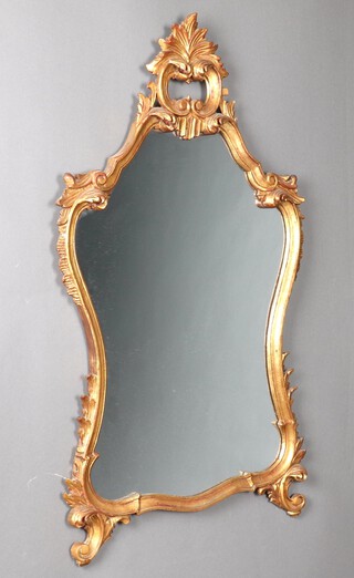 A 1950's Rococo style shaped plate mirror contained in a carved gilt wood frame 104cm x 60cm 