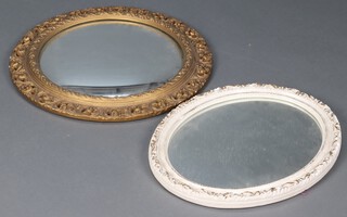 A circular convex plate wall mirror contained in a decorative gilt plaster frame 60cm, and an oval ditto in a white and gilt frame 54cm x 44cm 