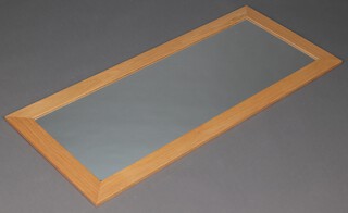 A rectangular plate wall mirror contained in an oak finished frame 135cm x 58cm 