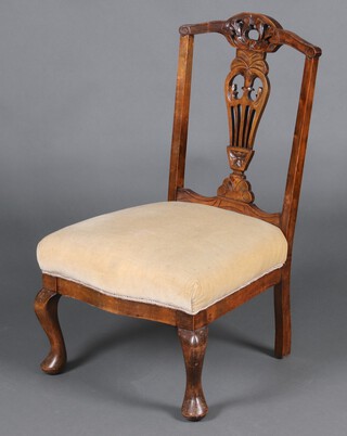 An Edwardian carved mahogany slat back nursing chair with over stuffed seat, on cabriole supports 