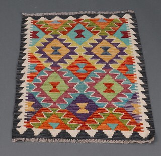 A black, green and brown ground Chobi Kilim with overall geometric design 73cm x 63cm 
