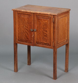 A 1930's oak sewing cabinet, the interior fitted 4 drawers enclosed by a panelled door, raised on square tapered supports 70cm h x 53cm w x 30cm d (water and contact marks in places)