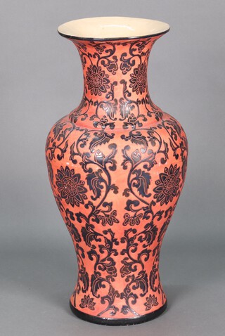 A Chinese style red and black floral patterned vase of club form 78cm x 29cm diam. 