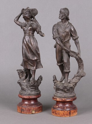 A pair of spelter figures of a fisherman and woman, raised on turned socle bases 38cm 