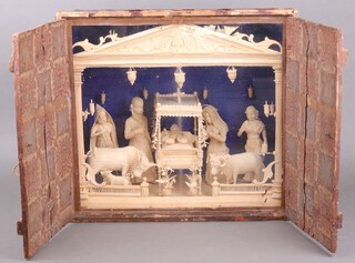 A 19th Century carved wooden fretwork Nativity scene, contained in a pine case with glazed front enclosed by panelled doors 45cm h x 48cm w x 23cm d  