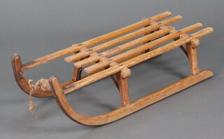 Davos, a wooden and metal framed toboggan 20cm h x 94cm l x 35cm w (break to 1 of the slats)  
