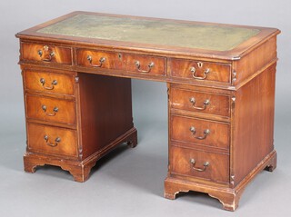 A kneehole pedestal desk with green inset writing surface, fitted 1 long and 8 short drawers 75cm h x 122cm w x 62cm d 