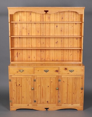 A pine dresser, the raised back fitted 4 shelves, the base fitted 3 drawers above triple cupboards 187cm h x 135cm w x 42cm d 