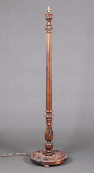 A turned and fluted beech standard lamp on a circular base 134cm h 