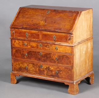 A Queen Anne quarter veneered walnut bureau with feather banding, the upper section fitted 2 short drawers, the fall front with book rest and revealing a well fitted interior with pigeon holes and drawers above 3 long drawers with ring drop handles, raised on bracket feet 104cm h x 101cm w x 55cm d 