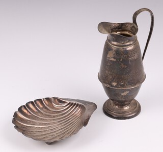 A silver scallop shaped butter dish Sheffield 1903 by Atkin Brothers (marks rubbed) 50 grams, together with a silver cream jug Birmingham 1910 by Syner & Bedoes 116 grams 