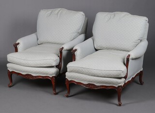 A pair of Edwardian carved mahogany show frame armchairs upholstered in blue material, raised on cabriole supports 82cm h x 80cm w x 69cm d 