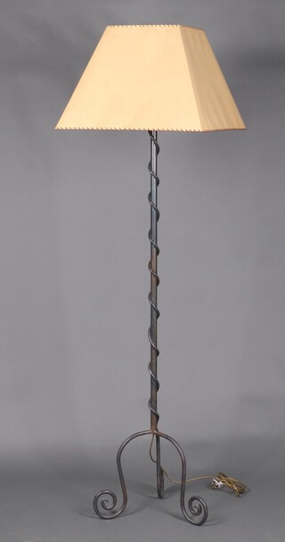A wrought metal standard lamp with spiral decoration and paper lamp shade 165cm h x 