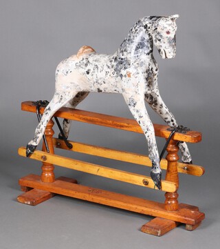 A Barker & Sons, a dapple grey rocking horse on a swing base, circa 1935, worn makers label to the base 89cm h x 89cm l x 34cm w