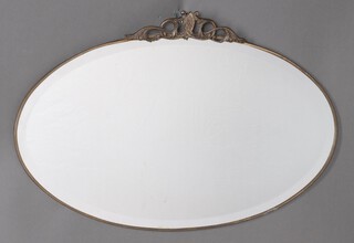 A 1920's oval bevelled plate frameless mirror with pierced metal decoration to the top 43cm x 67cm 