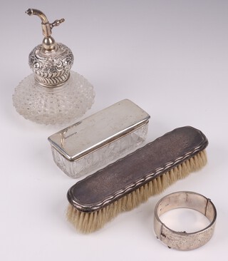 A rectangular glass pin jar with silver lid Birmingham 1915, an engraved silver bangle Chester 1957 (some dents) 68 grams, a silver backed hairbrush and a cut glass perfume atomiser with silver collar 