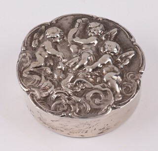 A silver pill box the lid embossed figures of musical cherubs, London 1977, makers mark DE, 4cm, 38 grams 