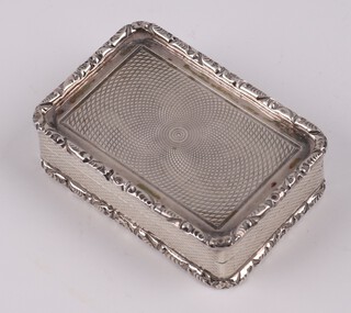 A Georgian style silver pill box with cast rim, engine turned decoration, parcel gilt interior and hinged lid, London 1969 by Ramsden & Roed, 4.5cm,  40 grams 