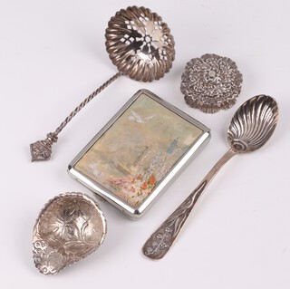 A circular embossed silver pill box Birmingham 1902 by Adie & Lovekin 3cm (hinge loose), a silver sifter spoon Birmingham 1896, a spoon with scallop bowl marked Sterling Duhme & Co., an embossed caddy spoon in the form of a leaf and a chrome match slip 