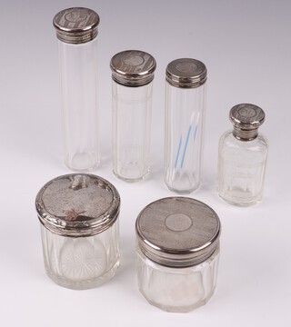 A panel cut dressing table jar with silver lid London 1925 7cm together with 1 other Chester (marks rubbed) 7cm, a faceted glass scent bottle with silver lid and 3 pin jars with silver lids  