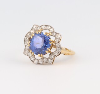 An 18ct yellow gold and platinum dress ring set a sapphire approx. 4.40ct, surrounded by 24 diamonds  clarity SI - I1, colour H/I approx. 0.48ct, size K, 4.29 grams 