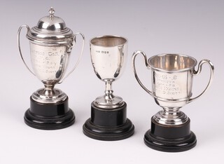 A silver twin handled trophy cup, London 1924 (marks rubbed), 6cm, a silver twin handled trophy cup (marks rubbed), a silver goblet shaped trophy cup, 101 grams 