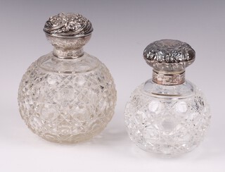 An Edwardian cut glass scent bottle complete with glass stopper and embossed silver lid Chester 1908 10cm (minor chips) together with a Victorian style scent bottle with stopper and embossed silver lid Birmingham 1996 9cm 
