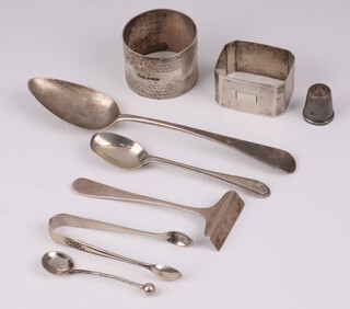 A Georgian silver Old English pattern silver spoon (marks rubbed), a silver napkin ring with engine turned decoration Birmingham 1932, ditto Birmingham 1944, child's silver pusher, teaspoon with beadwork decoration, pair of sugar tongs, thimble and a salt spoon, 135 grams 
