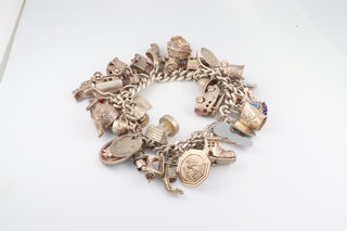 A silver curb link charm bracelet hung 35 numerous charms 98 grams gross