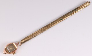 A lady's Mepa 18ct gold cased wristwatch with rectangular dial, Arabic numerals and gilt metal bracelet 