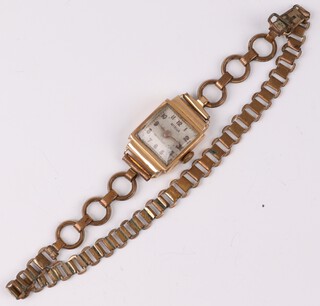 A lady's 18ct gold cased wristwatch, the square dial with Roman numerals, on a gilt metal bracelet 