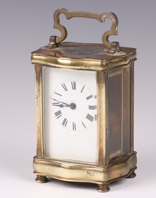 A French 8 day carriage timepiece with 5cm enamelled dial, Roman numerals, contained in a shaped gilt metal case 11cm x 8cm x 8cm, complete with key 