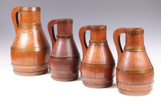 Two oak and copper coopered Devon pitchers by J. H. Fry of Barnstaple 37cm and 30cm together with 2 similar coopered jugs 30cm 