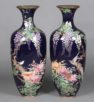 An impressive pair of 19th Century Japanese black ground and floral patterned cloisonne enamelled vases decorated birds amidst branches 85cm 