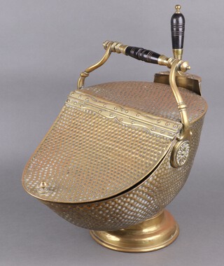 A Victorian embossed brass lidded coal scuttle, raised on a circular base with turned ebony handle and shovel 43cm h x 33cm w x 45cm d  