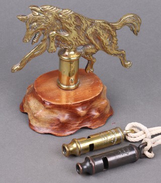 Of Scouting interest, a brass standard finial in the form of a running wolf, raised on a wooden base, converted as a paperweight 15cm, together with The Metropolitan patent whistle and The City Patent whistle on a lanyard  