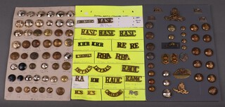A collection of metal shoulder titles including Kings Royal Rifles, The Loyal Regiment, collection of Royal Artillery buttons and cap badges 