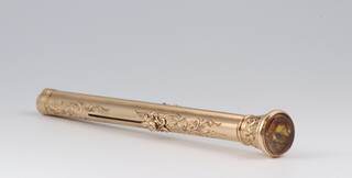 A yellow gold testing as 14ct, dip pen/pencil, in the form of a column with foliate decoration set a coloured stone to the terminal, gross weight 13.7 grams 