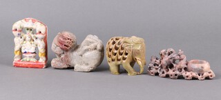 An Indian carved soap stone figure of a Deity 12cm, do. brush pot decorated monkey and boar 7cm , an Eastern carved soapstone figure of a Dog of Fo 13cm, a hardstone figure of an elephant 9cm 