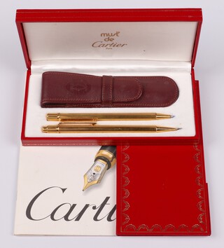 A Must de Cartier pen set, with gold plated ballpoint pen and propelling pencil, cased and with original paperwork 