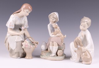 Three Lladro figures - seated girl with basket of tulips 3515 26cm boxed, seated boy with puppy 11 4 18cm boxed, seated girl with puppy and lantern A-11 N 23cm 