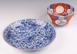 A 19th Century Japanese Imari porcelain bowl with panelled decoration 22cm (a/f and riveted) and an 18th Century Chinese blue and white floral patterned charger 38cm (with repair) 