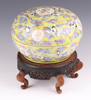 A late 19th Century Chinese circular yellow bowl and cover, the lid decorated storks amidst branches the base with 4 character mark, on a wooden stand 28cm