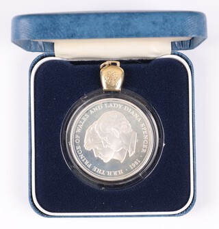 A yellow gold, testing as 14ct charm in the form of a bell 1.2 grams together with a 1981 silver proof Royal Wedding crown 