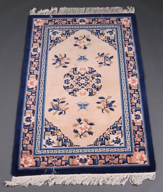 A 1930's blue and pink ground Chinese floral patterned rug with central medallion decorated butterflies and birds 156cm x 93cm 
