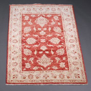 A yellow and orange ground Caucasian style rug having a central floral medallion within a multi row border 147cm x 101cm 